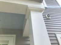 A close up of a white porch post on a house.
