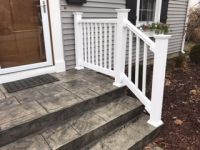 There is a white railing on the steps of a house.