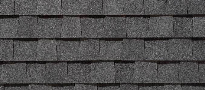 A close up of a row of gray shingles on a roof.