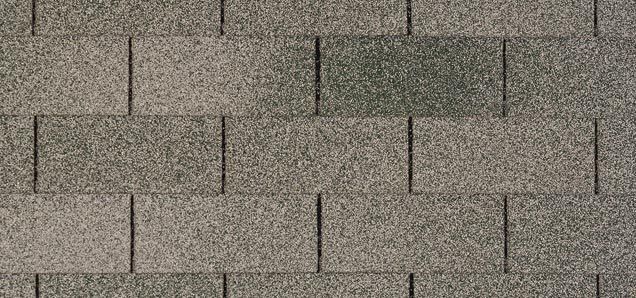 A close up of a roof tile with a gray shingle.