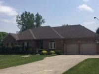A large brick house with two garages and a driveway.