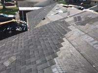 An aerial view of a roof with shingles being installed.