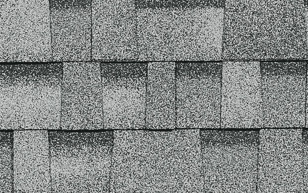 A black and white photo of a roof with shingles.