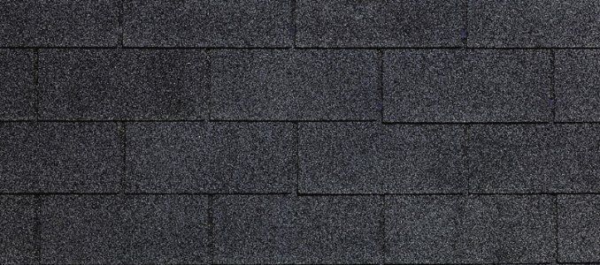 A close up of a row of black shingles on a roof.