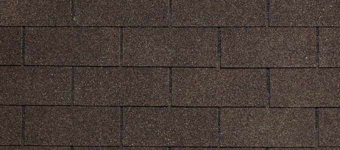 A close up of a row of brown shingles on a roof.