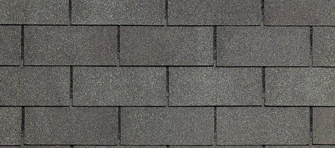 A close up of a row of gray shingles on a roof.