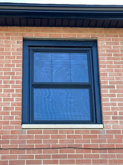 A window on a brick building with a black frame