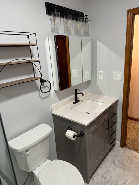 A bathroom with a toilet a sink and a mirror