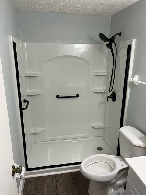 A bathroom with a walk in shower and a toilet