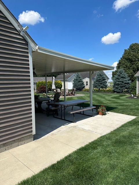 A covered patio with a picnic table underneath it