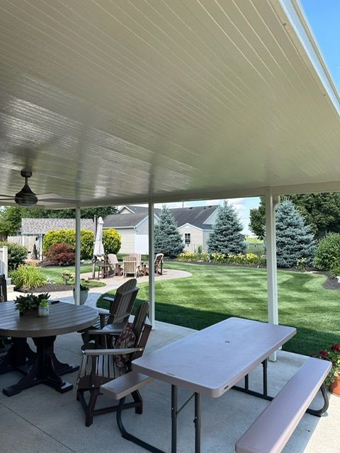 A patio with a table and chairs under a canopy