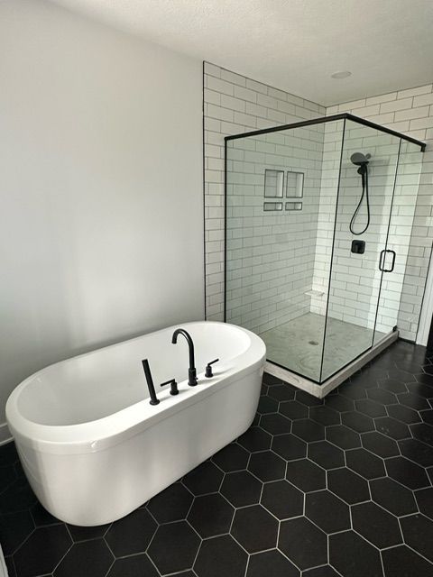 A bathroom with a bathtub and a shower.
