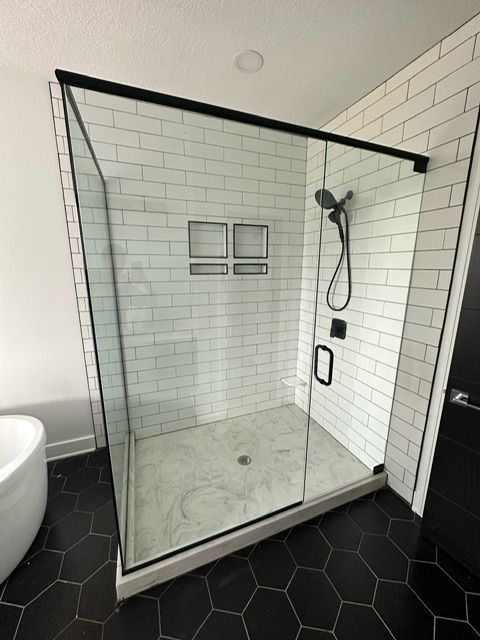 A bathroom with a walk in shower and a bathtub.