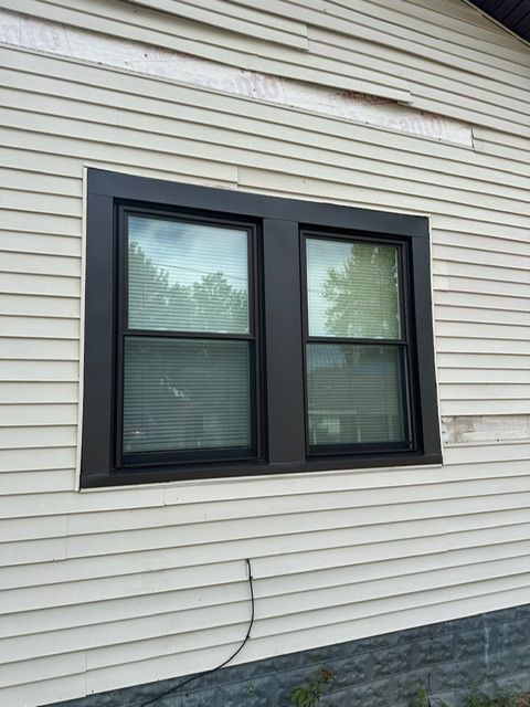 A house with two windows on the side of it.