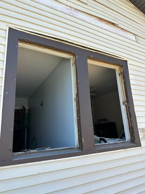 A white house with a window that is missing