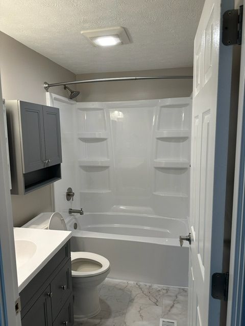 A bathroom with a toilet a sink and a bathtub