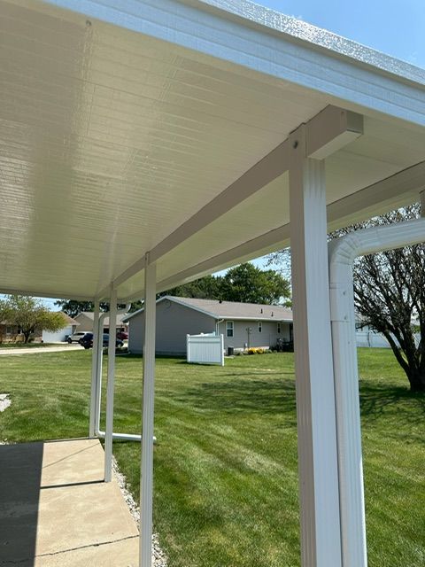 A white covered walkway with a house in the background
