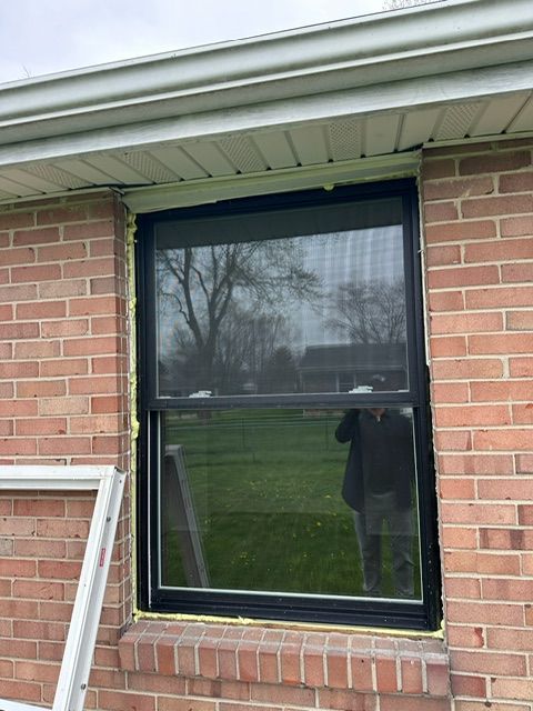 A window is being installed on a brick building