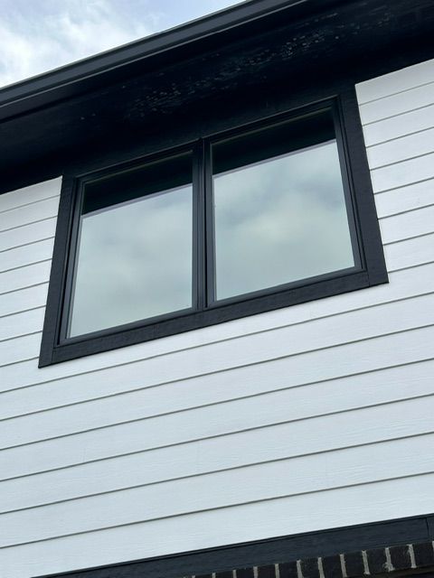 A white house with black trim and two windows