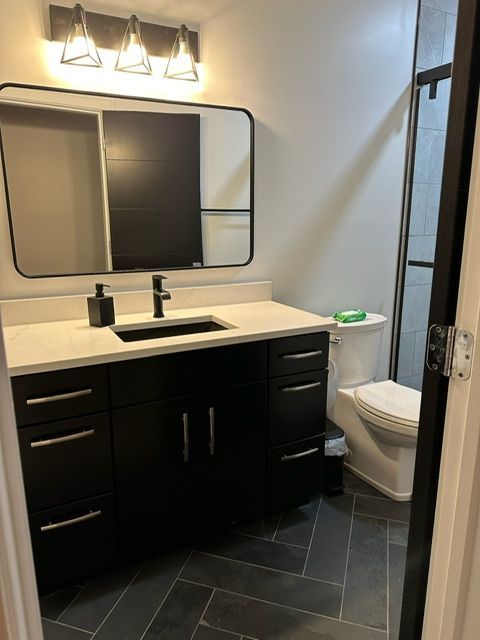 A bathroom with a sink a toilet and a mirror