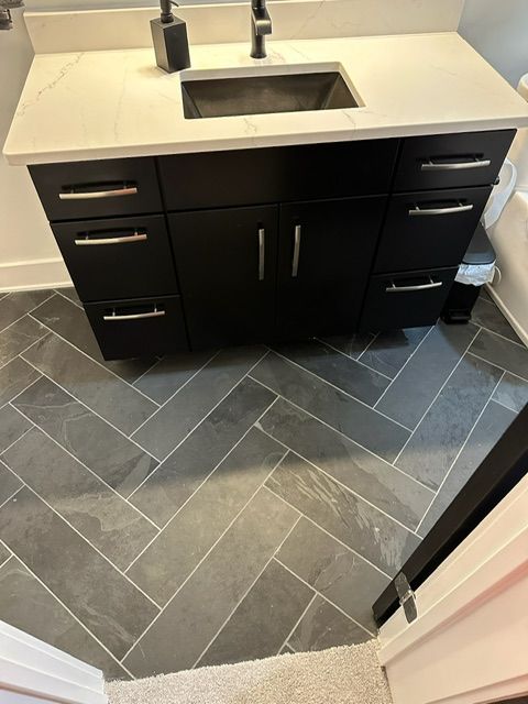 A bathroom with a sink and a herringbone floor