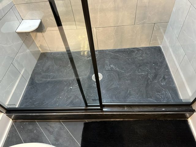 A bathroom with a sliding glass shower door