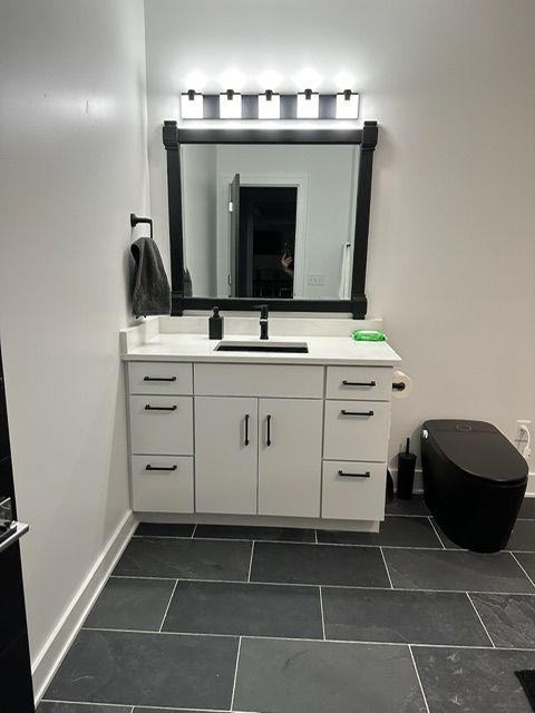 A bathroom with a sink a mirror and a toilet