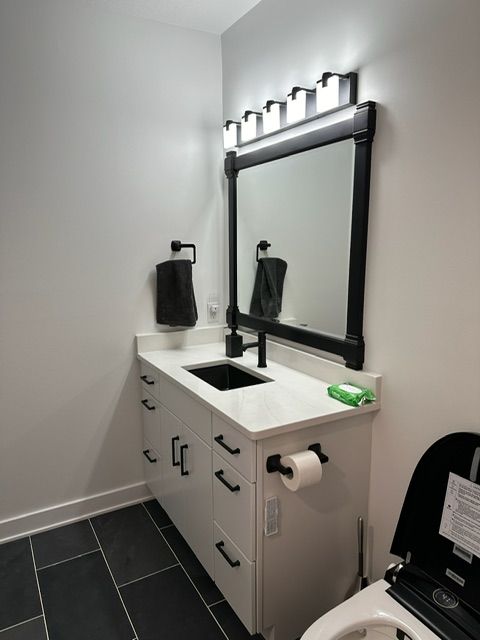 A bathroom with a toilet a sink and a mirror