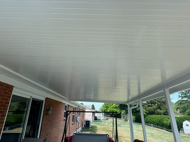 There is a swing on the porch of a house.