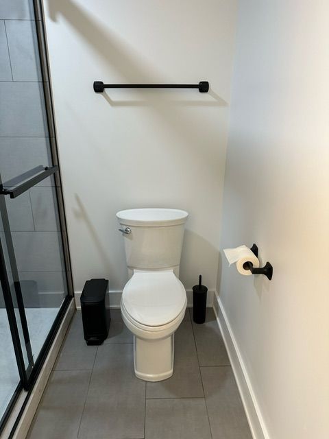 A bathroom with a toilet and a towel rack