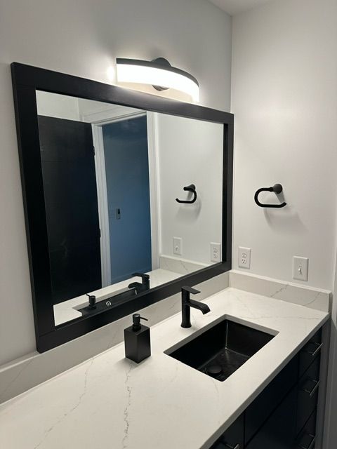 A bathroom with a large mirror and a sink