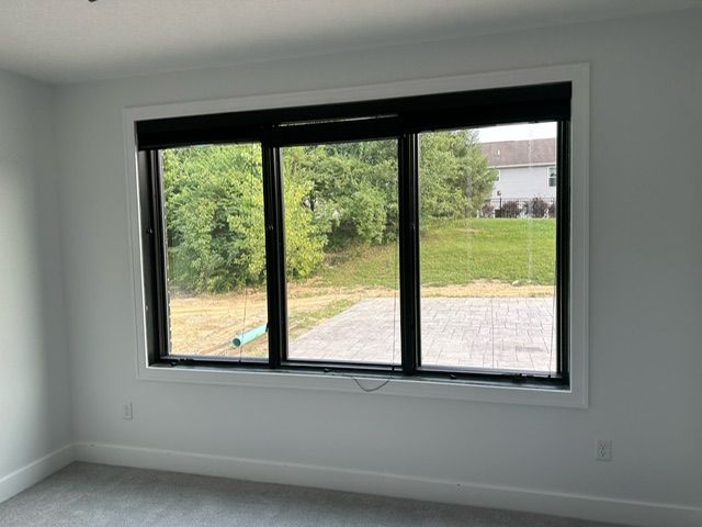 There is a large window in the middle of the room with a view of the backyard.