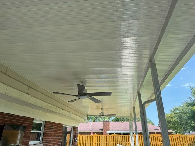 A ceiling fan is hanging from the ceiling of a porch.