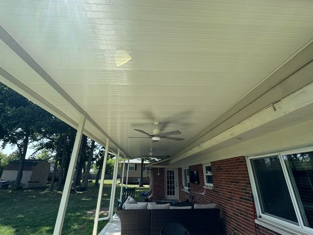 There is a ceiling fan on the porch of a house.