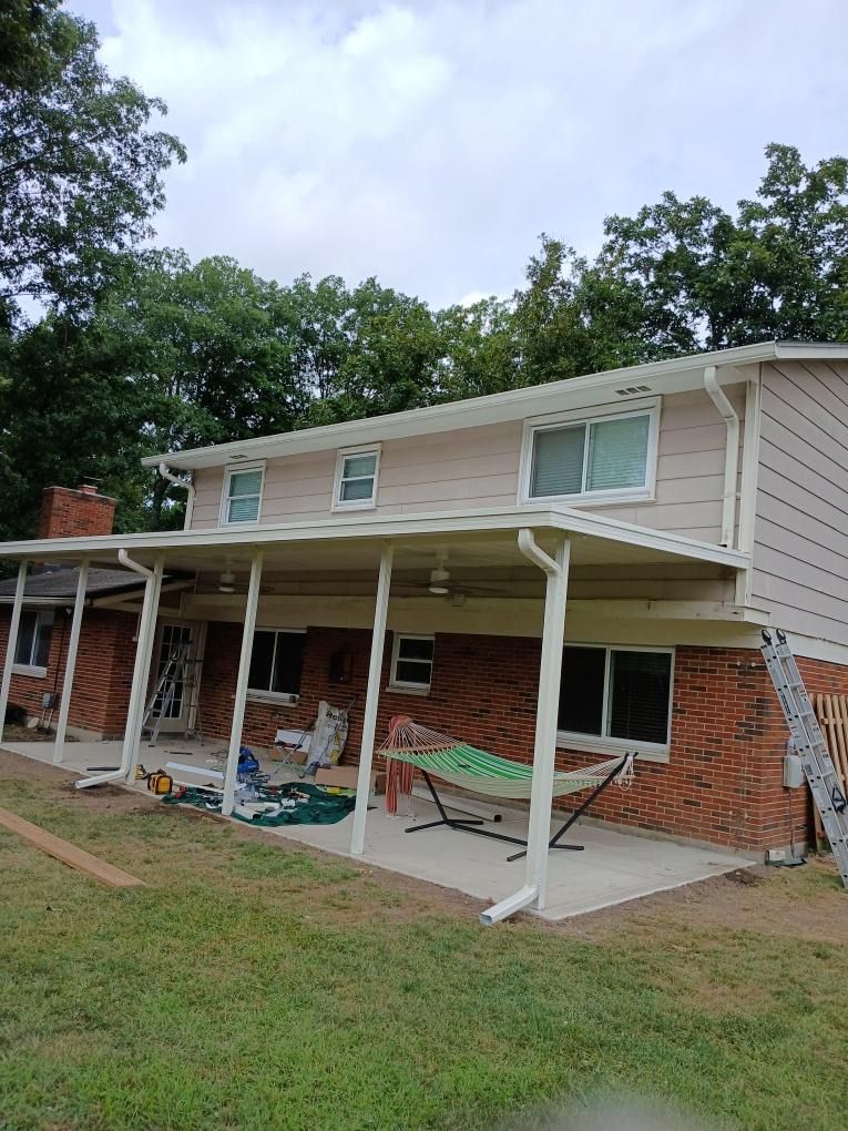A house with a porch and a ladder in front of it.