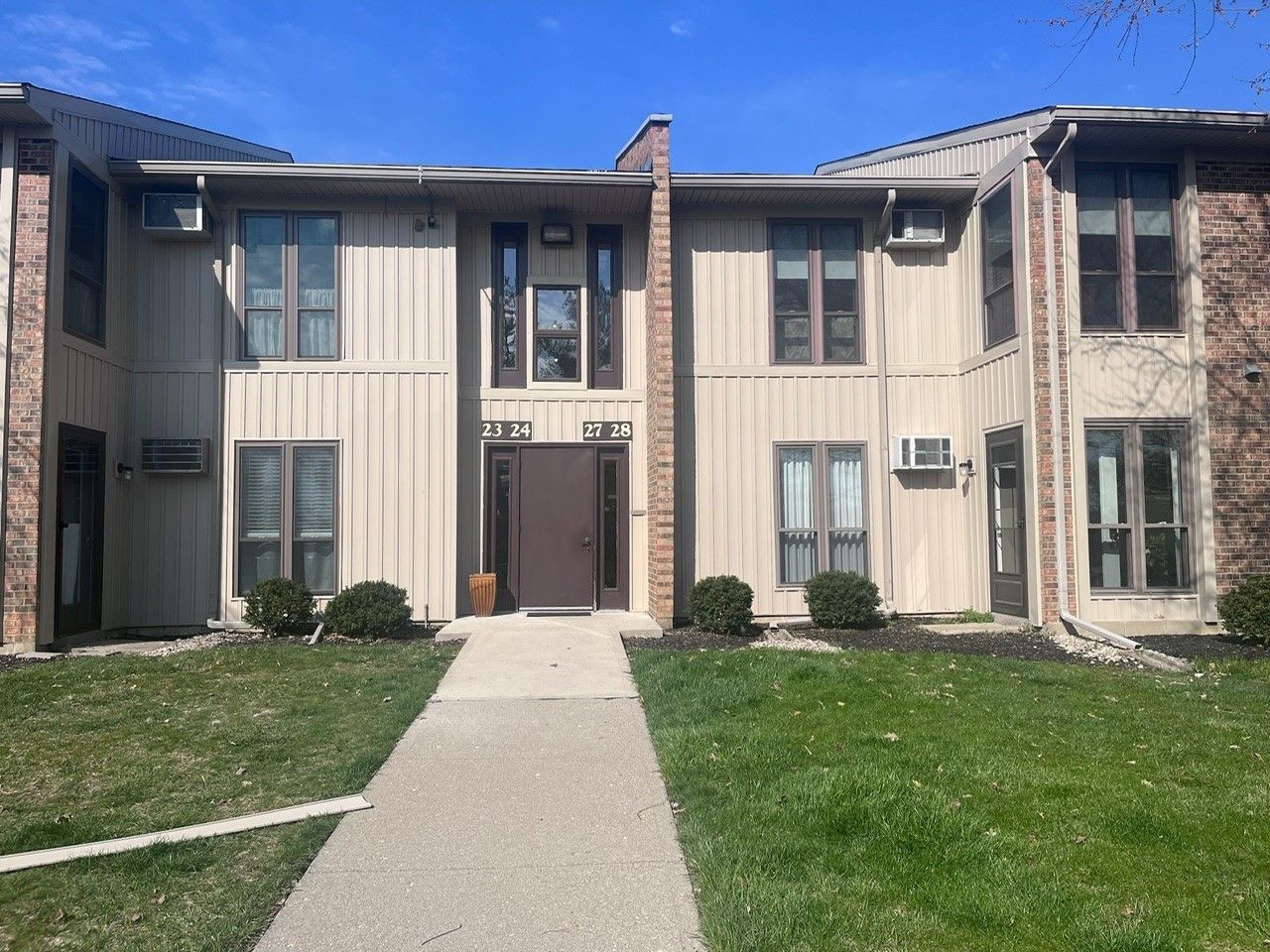 A large apartment building with a walkway leading to it.