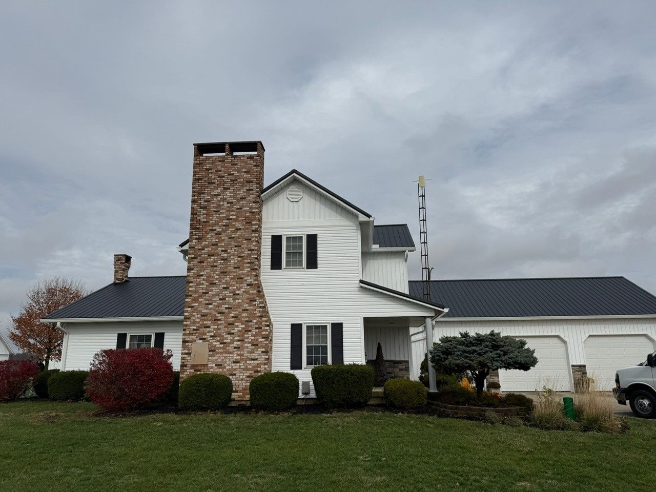 A white house with a chimney on the side of it