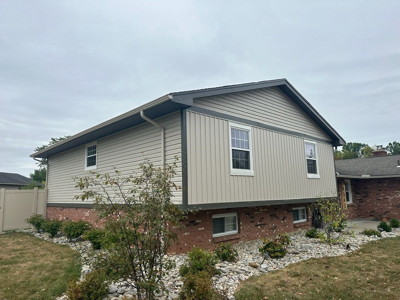 A large house with a lot of windows is sitting on top of a lush green hillside.