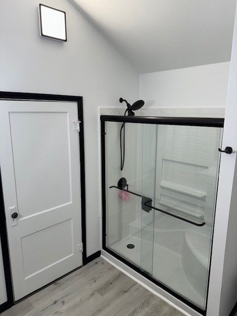 A bathroom with a sliding glass shower door.