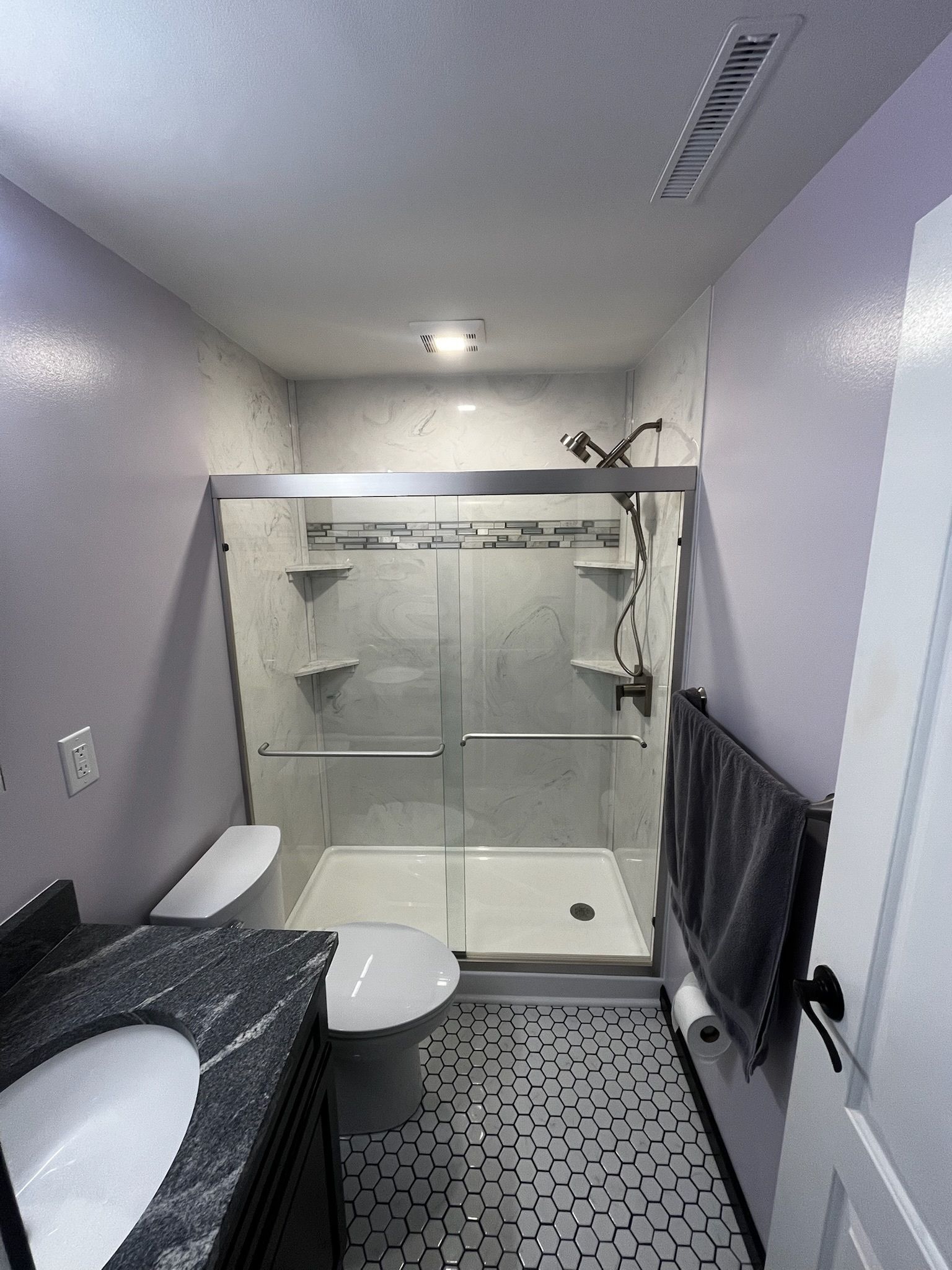 A bathroom with a toilet, sink, and shower.