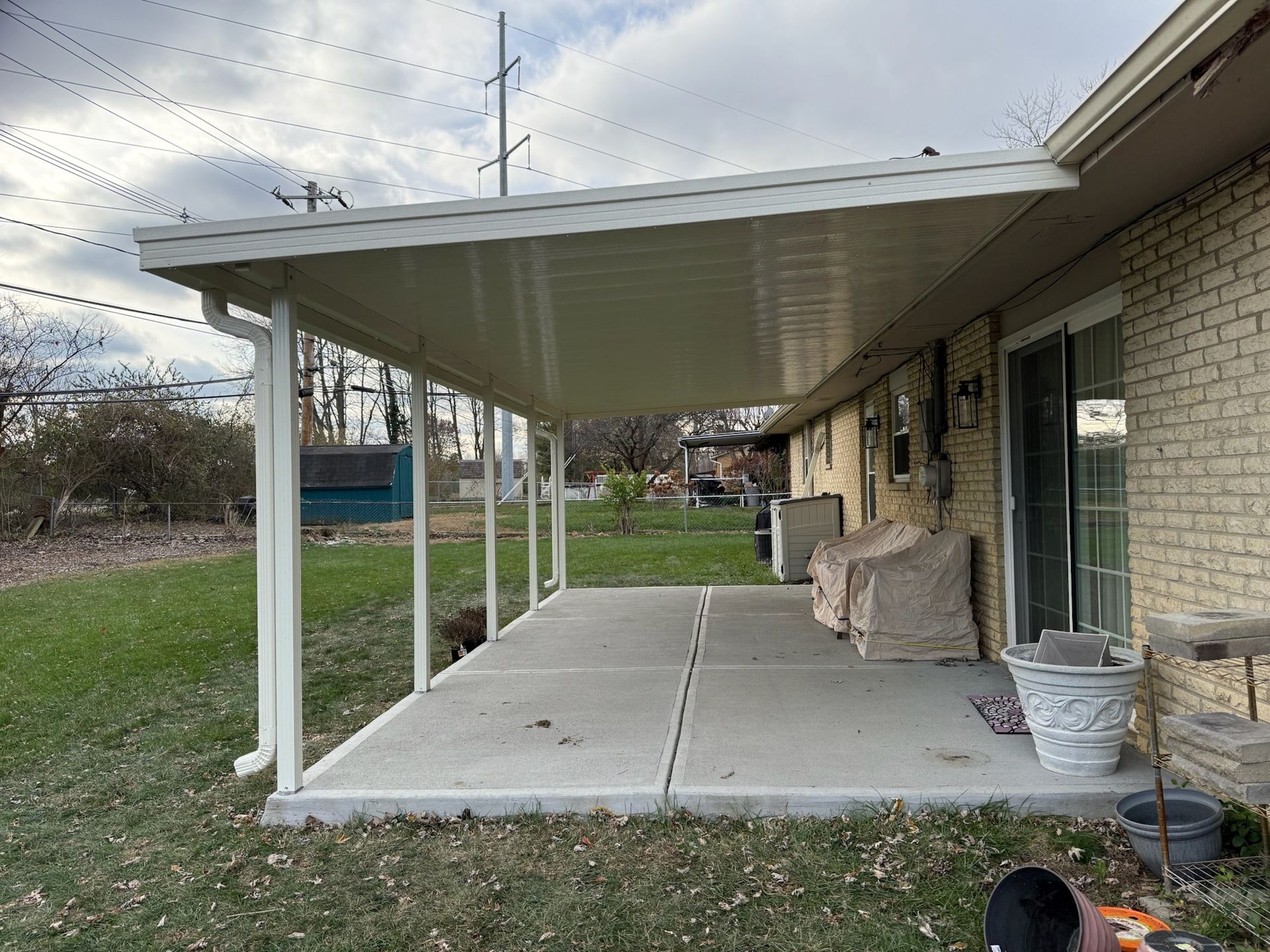 A brick house with a covered porch and a sliding glass door.