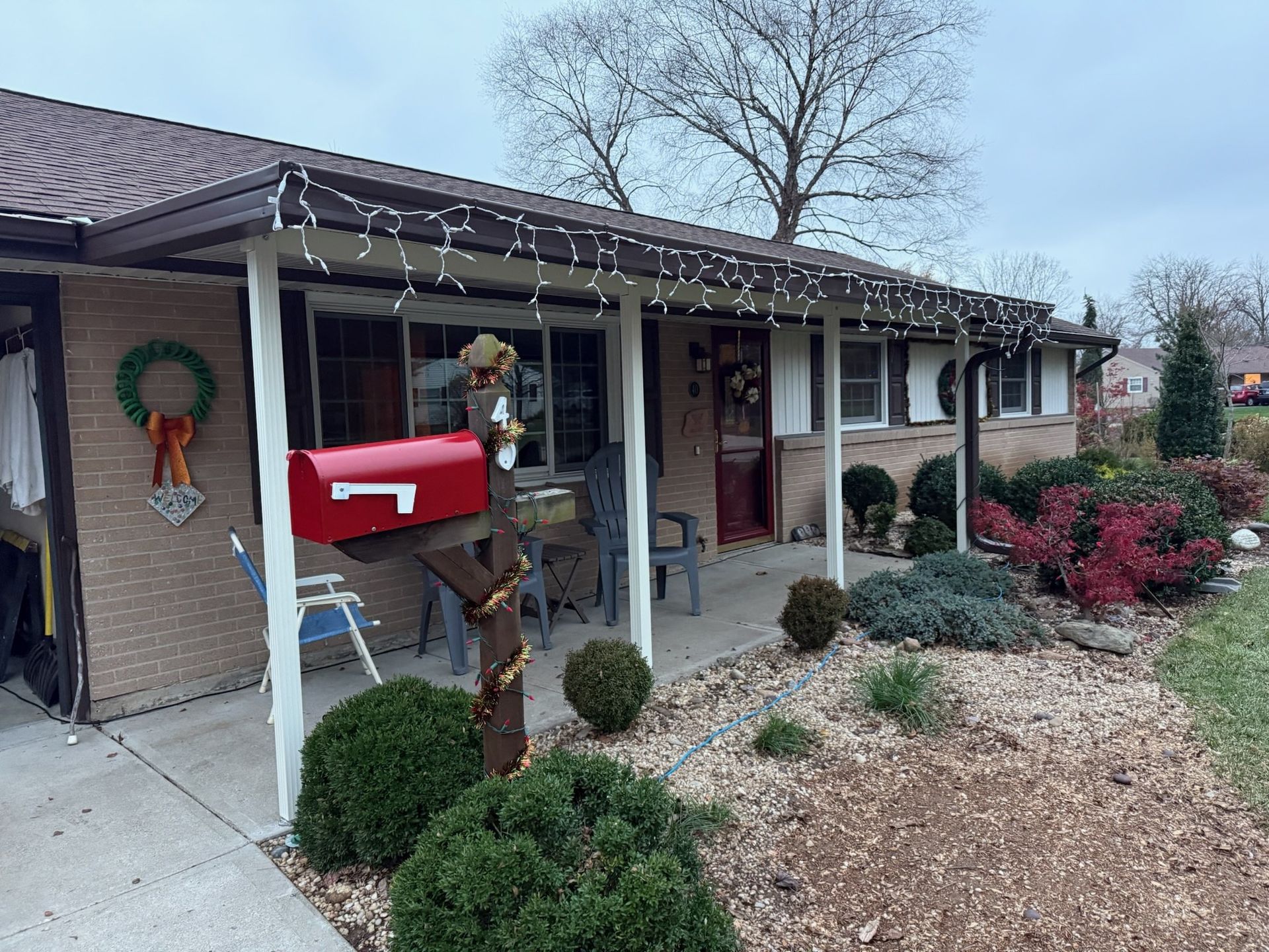 A red mailbox is on the porch of a house.