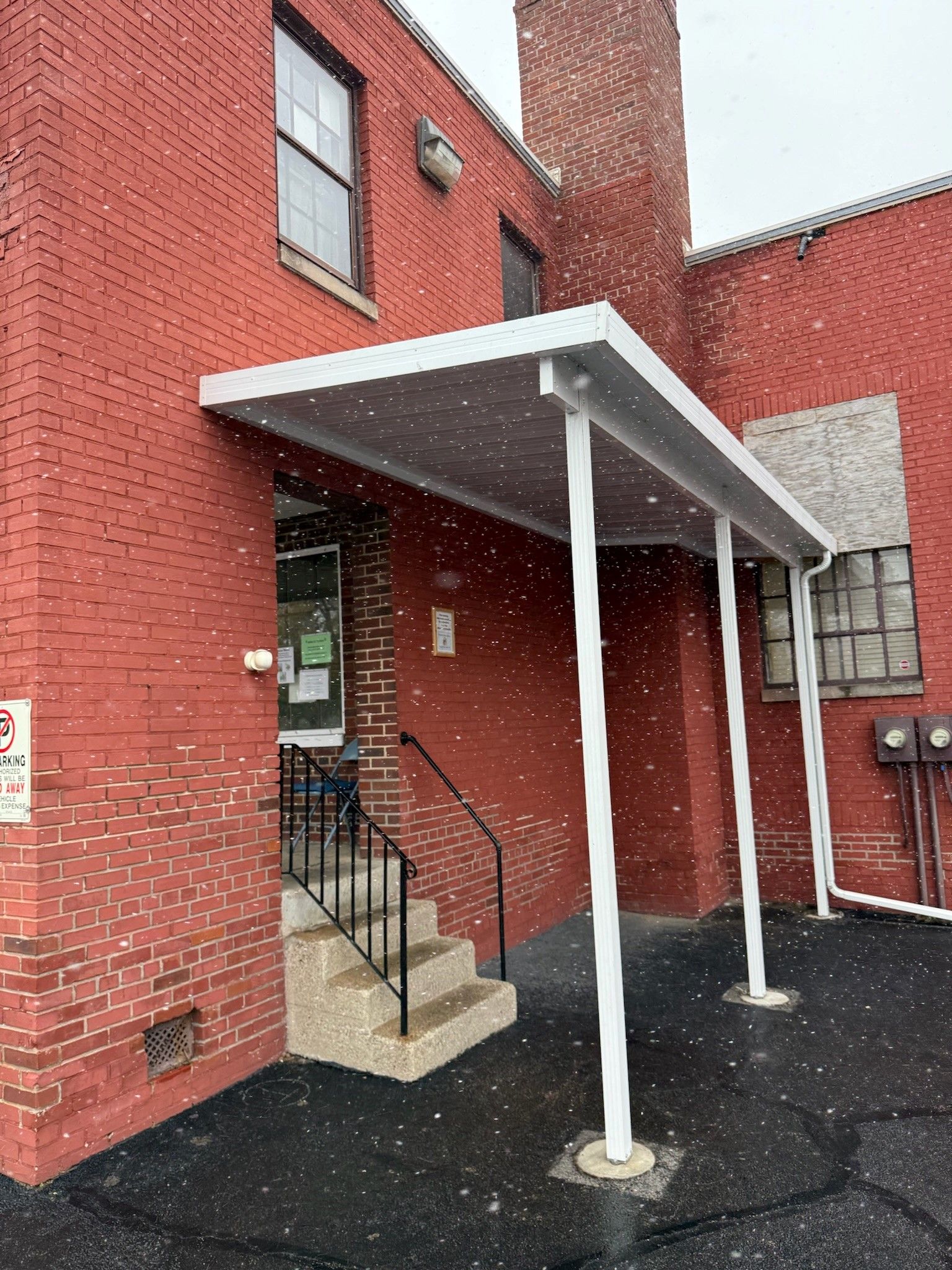 A red brick building with a white canopy over the entrance.