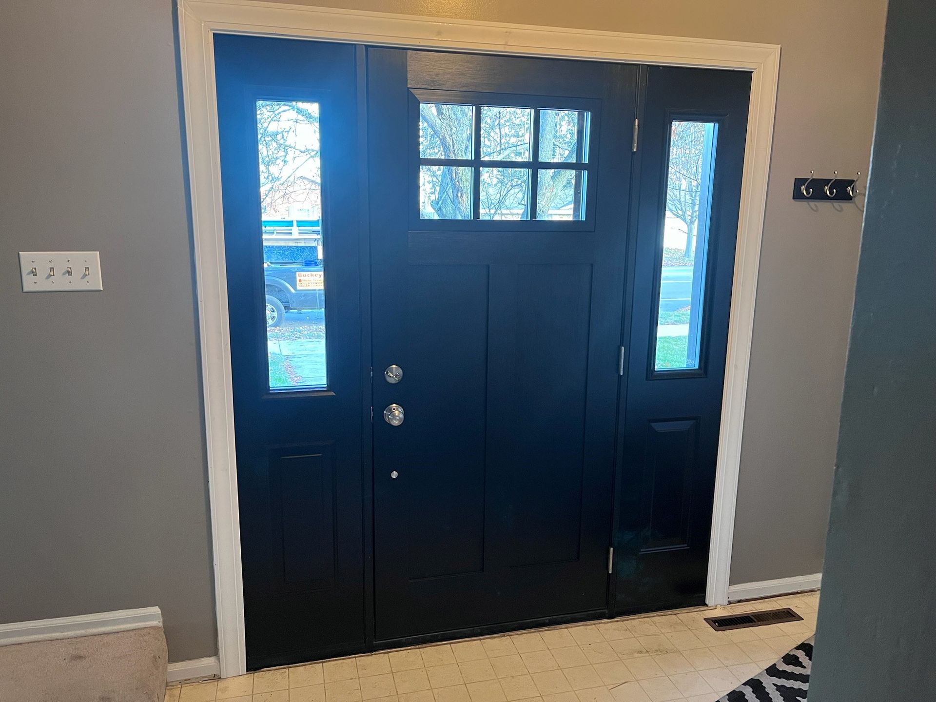 A black door with a white trim is in a room with a gray wall.