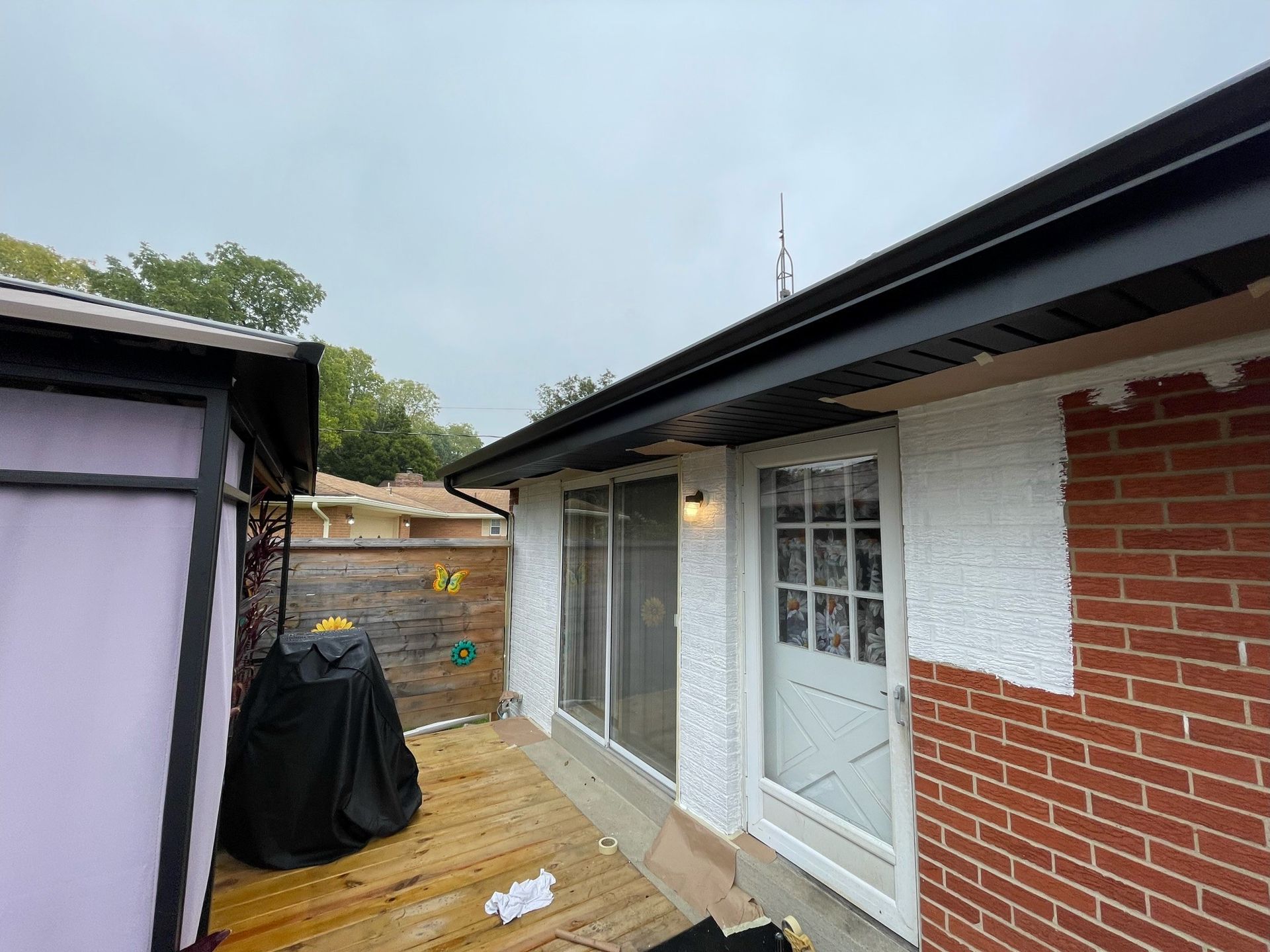 A brick house with a wooden deck and a sliding glass door.