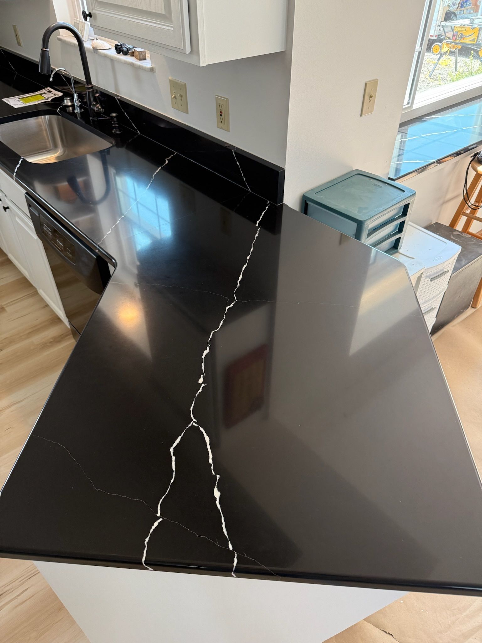 A kitchen with a black granite counter top and stainless steel appliances.