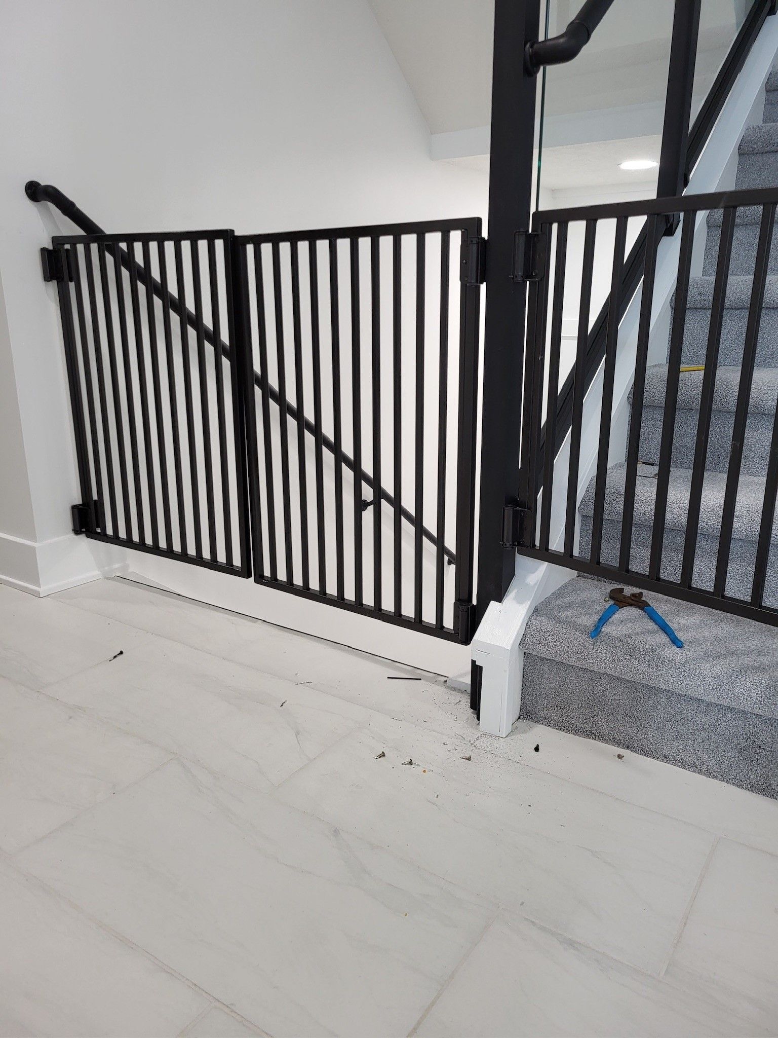 A black metal fence is surrounding a staircase in a house.