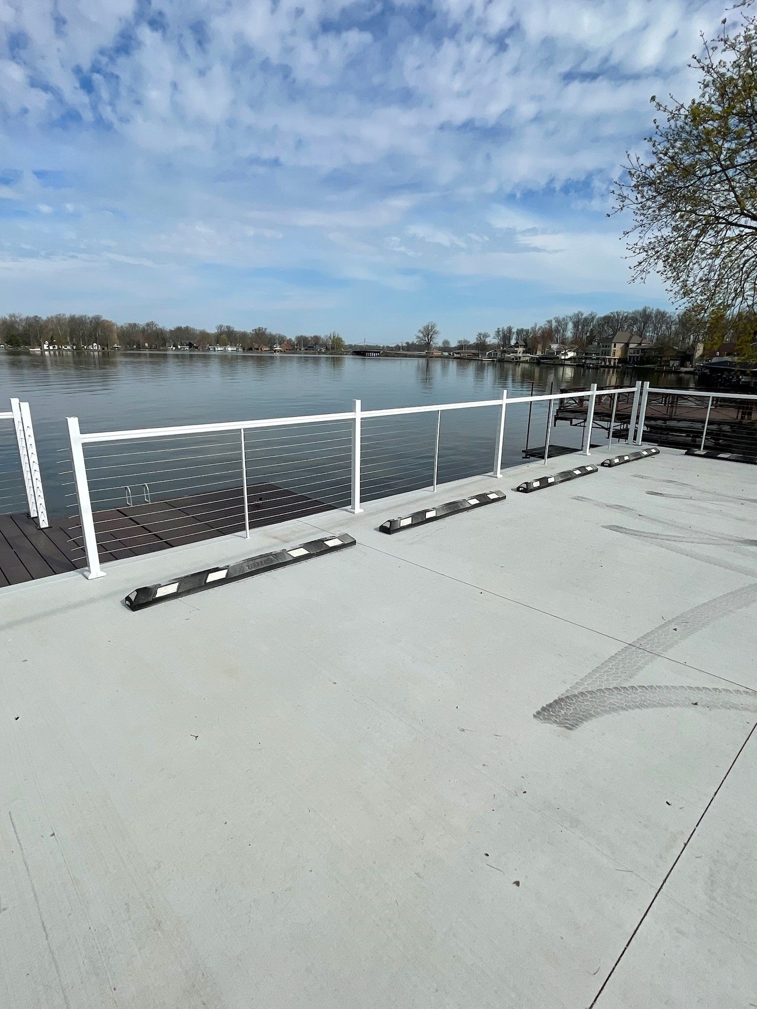 A dock with a white railing overlooking a body of water.