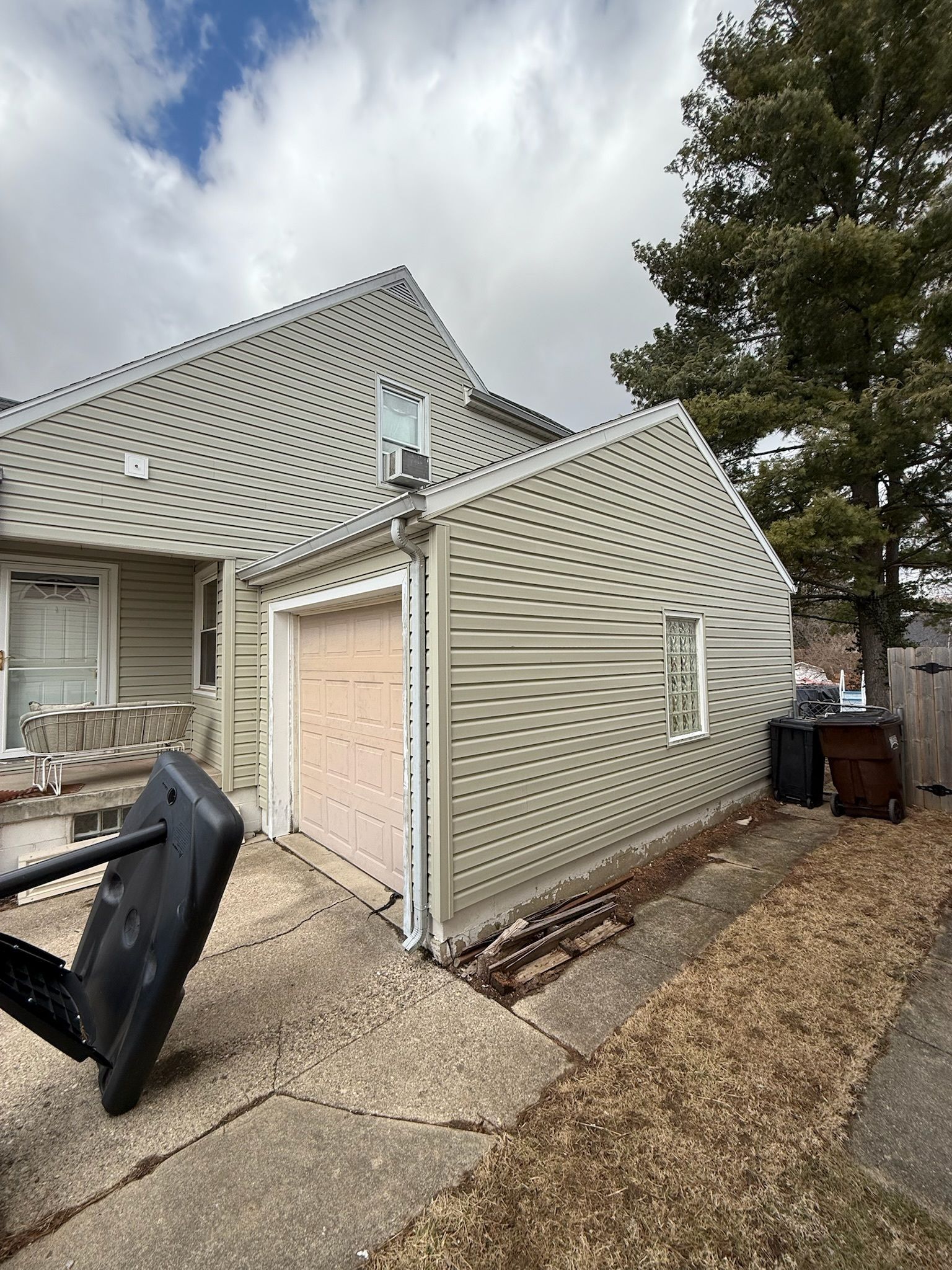 A house with a garage and a basketball hoop in front of it.