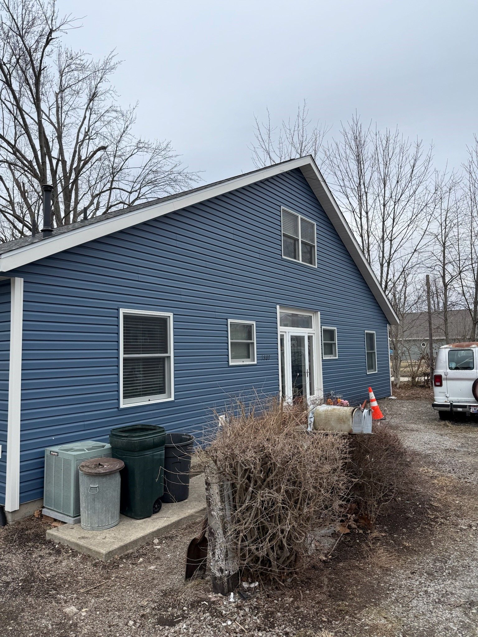 A blue house with a white van parked in front of it.